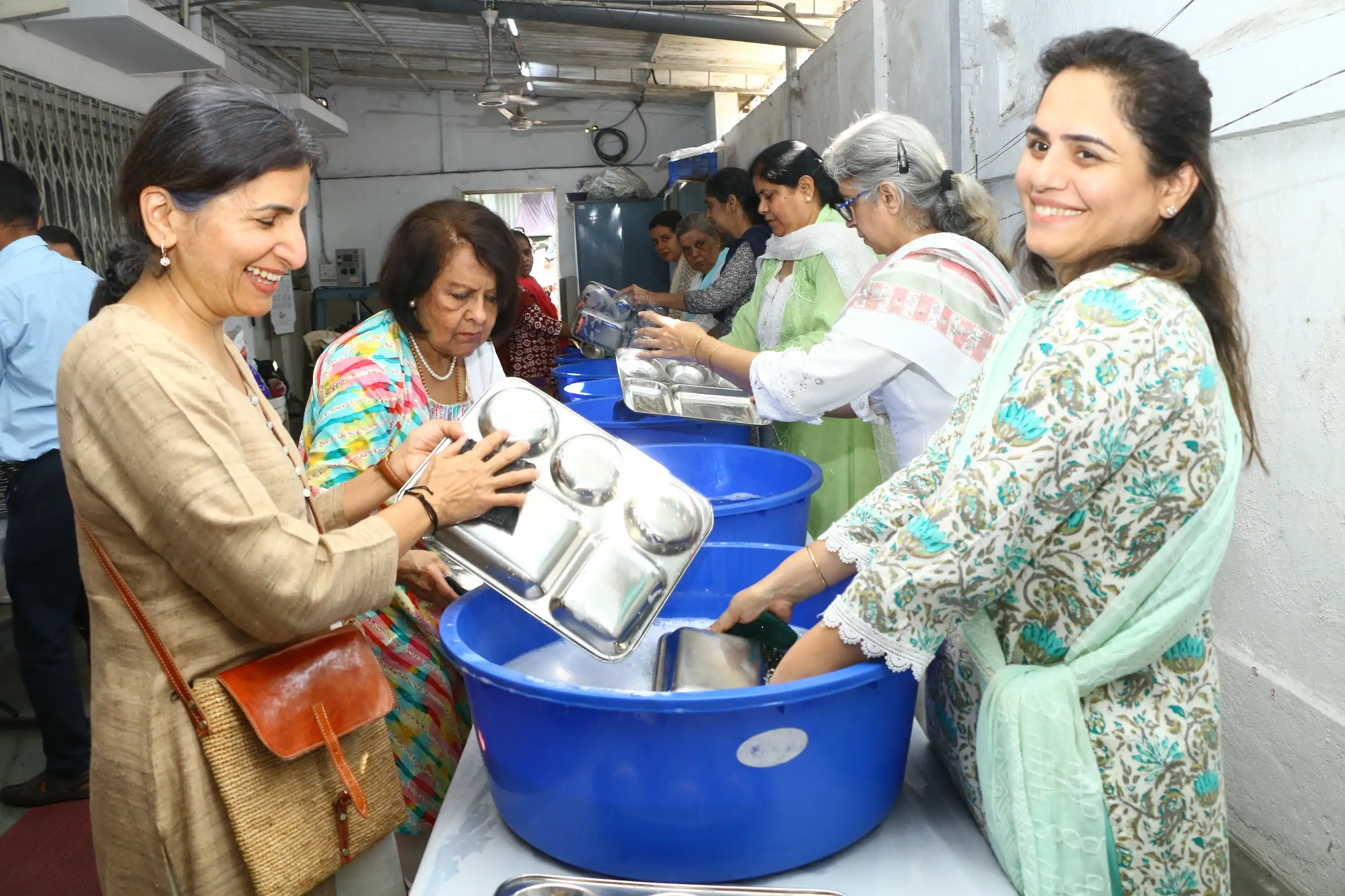 Hands at work, hearts in service- Devotees washing dishes in langar seva